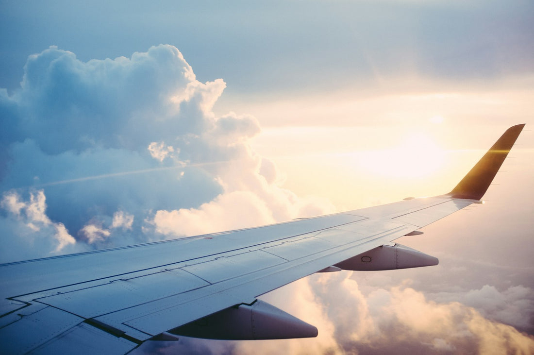 Airplane wing above clouds for planning flights to Curaçao
