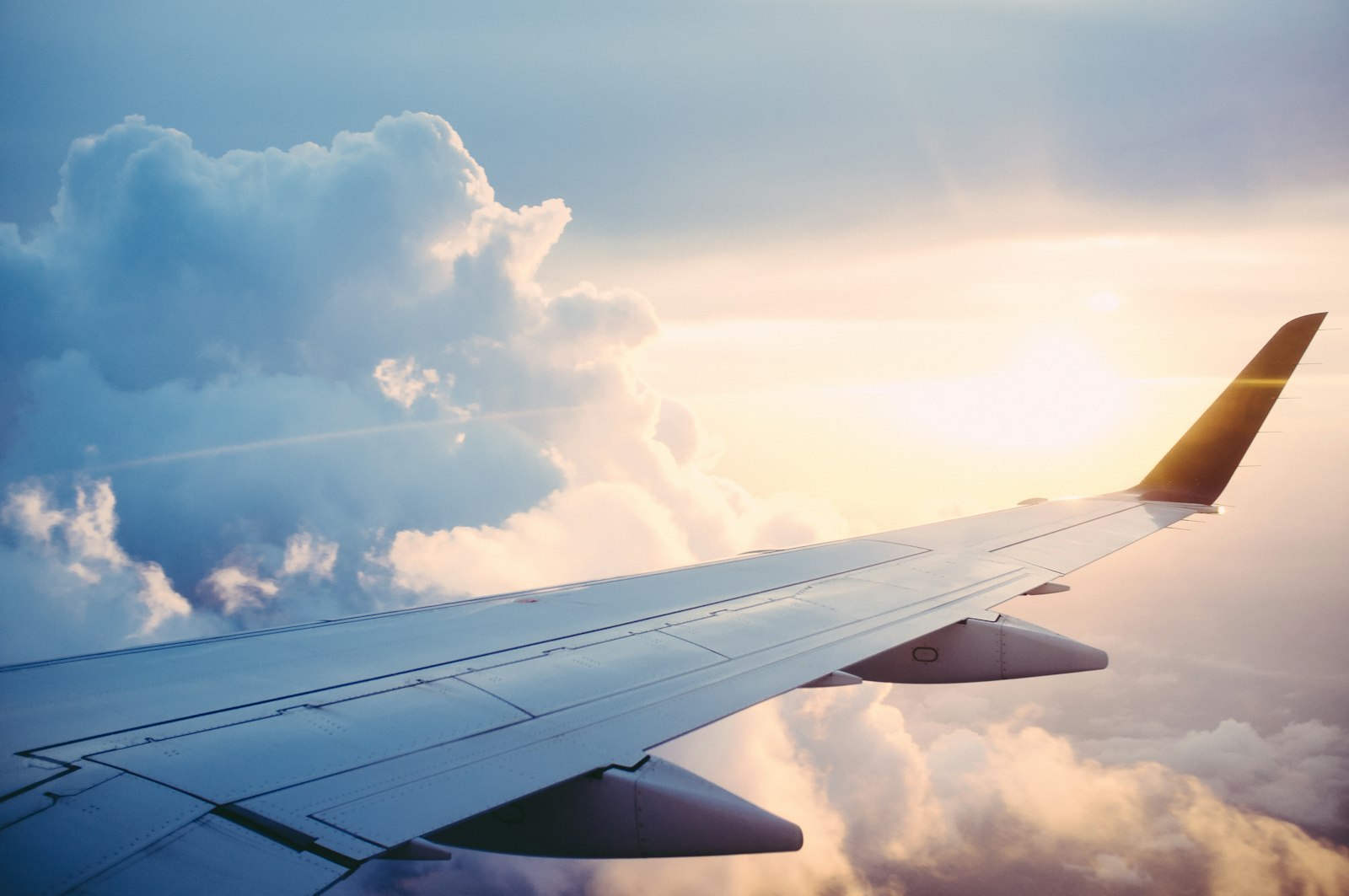 Airplane wing above clouds for planning flights to Curaçao